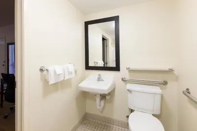 a bathroom with a sink and a toilet and a mirror at Red Roof Inn PLUS+ West Springfield in Springfield