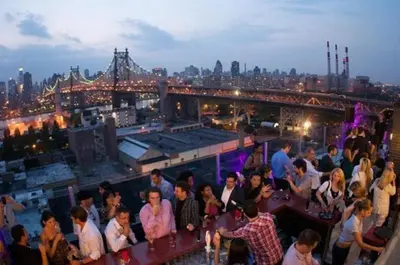 a group of people standing on top of a bar at Z NYC Hotel in Queens