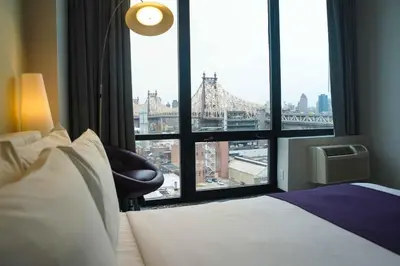 a hotel room with a bed and a large window at Z NYC Hotel in Queens