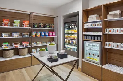 a shop with a table and an open refrigerator at AC Hotel by Marriott New York Downtown in New York