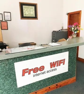 an office counter with a free wifi internet access sign at Village Motel in Ellenville