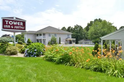 a sign for a flower inn and suites in a yard at Tower Inn and Suites of Guilford / Madison in Guilford