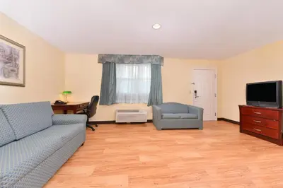 a living room with a couch and a tv at Tower Inn and Suites of Guilford / Madison in Guilford