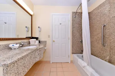a bathroom with a sink and a tub and a shower at Tower Inn and Suites of Guilford / Madison in Guilford