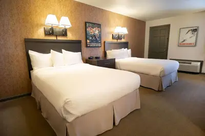 a hotel room with two beds with white sheets at The Yankee, Trademark Collection by Wyndham in Lenox
