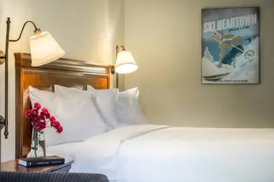a bedroom with a white bed with a poster on the wall at The Yankee, Trademark Collection by Wyndham in Lenox