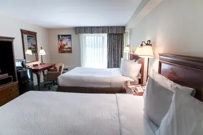 a hotel room with two beds and a desk at The Yankee, Trademark Collection by Wyndham in Lenox