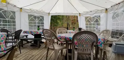 a white tent with tables and chairs on a deck at Whisperin' Pines Chalet in Cooperstown