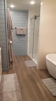 a bathroom with a shower and a toilet and a sink at Whisperin' Pines Chalet in Cooperstown