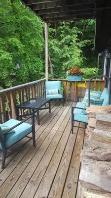 three blue benches sitting on a wooden deck at Whisperin' Pines Chalet in Cooperstown