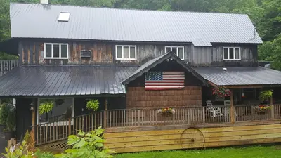 a house with an american flag on the front of it at Whisperin' Pines Chalet in Cooperstown