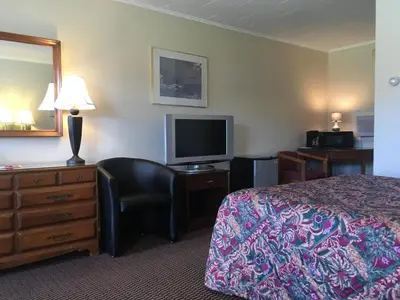 a hotel room with a bed and a flat screen tv at Catamount Motel in Bennington