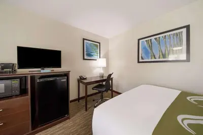 a hotel room with a bed and a flat screen tv at Quality Inn Great Barrington in Great Barrington