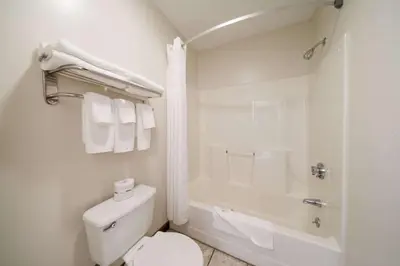 a white bathroom with a toilet and a bath tub at Quality Inn Great Barrington in Great Barrington