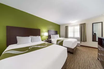 two beds in a hotel room with green walls at Quality Inn Great Barrington in Great Barrington