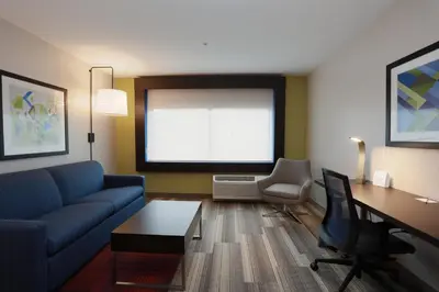 a living room with a couch and a table and a desk at Holiday Inn Express Oneonta by IHG in Oneonta