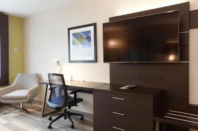 a hotel room with a desk and a large tv at Holiday Inn Express Oneonta by IHG in Oneonta