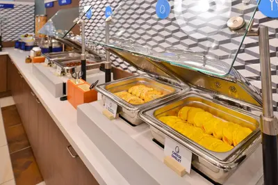 a buffet line with trays of food on display at Holiday Inn Express Oneonta by IHG in Oneonta