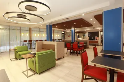 a restaurant with green chairs and tables and red chairs at Holiday Inn Express Oneonta by IHG in Oneonta