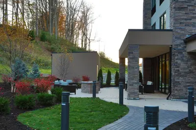 a building with a courtyard with tables and chairs at Holiday Inn Express Oneonta by IHG in Oneonta