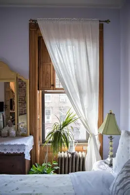 a bedroom with a bed and a window with a plant at Harlem Grand in New York