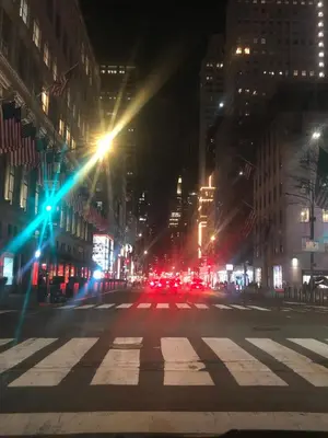 an empty city street at night with lights at Harlem Grand in New York