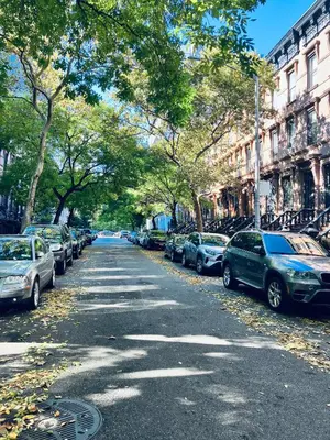 a street with cars parked on the sides of the road at Harlem Grand in New York