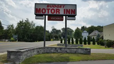 a sign for a motor inn on the side of a road at Budget Motor Inn- Stony Point in Stony Point