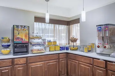 a kitchen with wooden cabinets and a counter top with food at Days Inn by Wyndham Elmsford in Elmsford