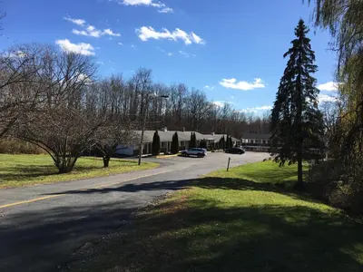 a street with a car driving down a road at Budget Motor Inn- Mahopac in Mahopac