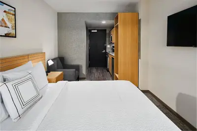 a hotel room with a bed and a living room at TownePlace Suites by Marriott New York Manhattan/Times Square in New York
