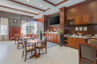a large kitchen with wooden cabinets and a table and chairs at Sheraton Tarrytown Hotel in Tarrytown