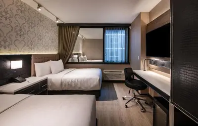 a hotel room with two beds and a desk at Aliz Hotel Times Square in New York