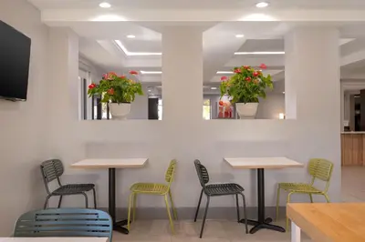 a restaurant with four tables and chairs and flowers at Spark by Hilton Fishkill in Fishkill