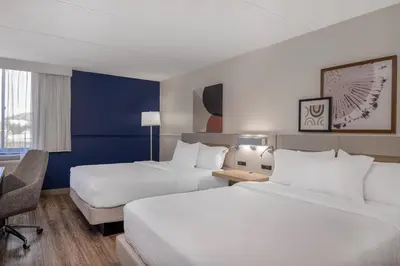 a hotel room with two beds and a desk at Spark by Hilton Fishkill in Fishkill