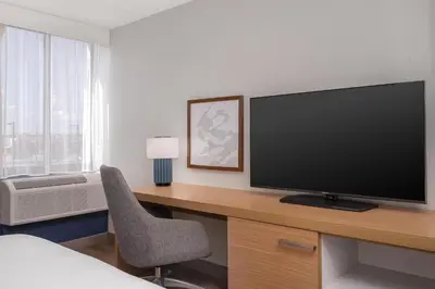 a room with a desk with a television and a chair at Spark by Hilton Fishkill in Fishkill