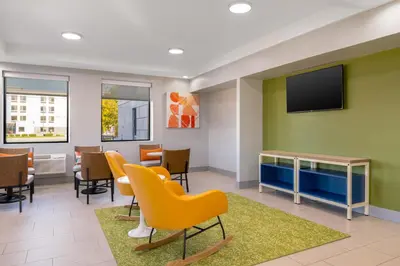 a waiting room with chairs and a flat screen tv at Spark by Hilton Fishkill in Fishkill