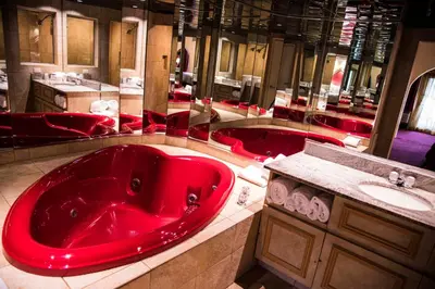 a bathroom with a large red tub and a sink at Paradise Stream Resort in Cresco