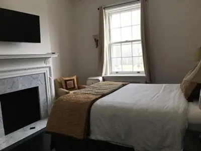 a bedroom with a bed and a fireplace and a television at Eastover Estate and Eco Village in Lenox