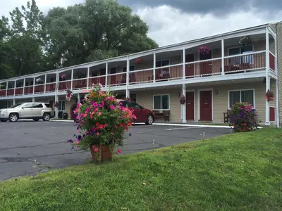 a large building with flowers in a parking lot at Cozy Corner Motel in Williamstown