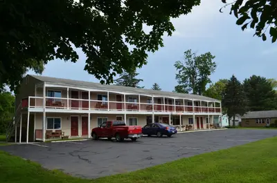 a building with a red truck parked in a parking lot at Cozy Corner Motel in Williamstown