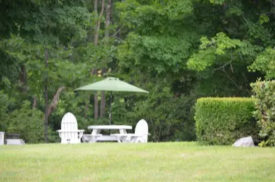 a table and chairs and an umbrella in a yard at Cozy Corner Motel in Williamstown