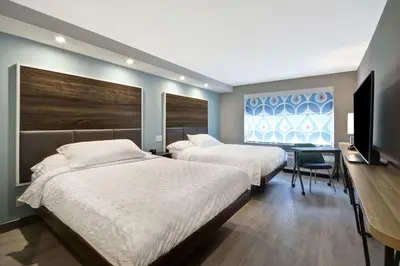 a bedroom with two beds and a desk and a television at Tru By Hilton Chicopee Springfield in Chicopee