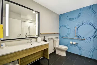 a bathroom with a toilet and a sink and a mirror at Tru By Hilton Chicopee Springfield in Chicopee