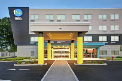 a front view of a hotel with yellow columns at Tru By Hilton Chicopee Springfield in Chicopee