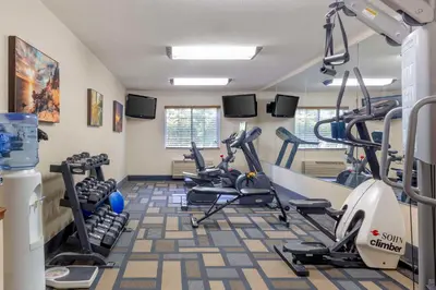 a gym with treadmills and ellipticals in a room at Best Western Plus Berkshire Hills Inn & Suites in Pittsfield