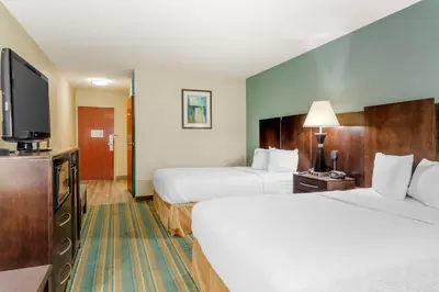 a hotel room with two beds and a flat screen tv at Best Western Plus Berkshire Hills Inn & Suites in Pittsfield