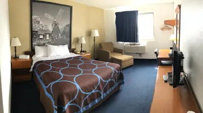 a hotel room with a bed and a chair at Super 8 by Wyndham Montgomery Maybrook in Montgomery