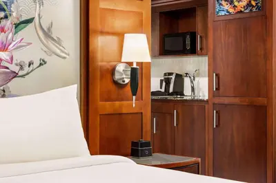 a bedroom with a bed and a cupboard with a microwave at Viana Hotel and Spa, Trademark Collection by Wyndham in Westbury