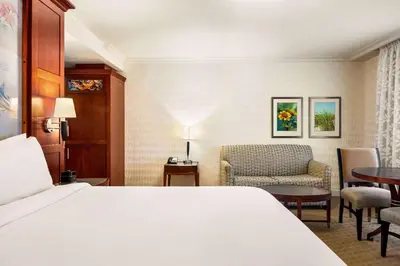 a hotel room with a bed and a chair at Viana Hotel and Spa, Trademark Collection by Wyndham in Westbury
